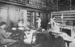 Despacho del administrador Federico Castellanos, rodeado de sus auxiliares en la Farmacia La Purísima (Ca. 1919).