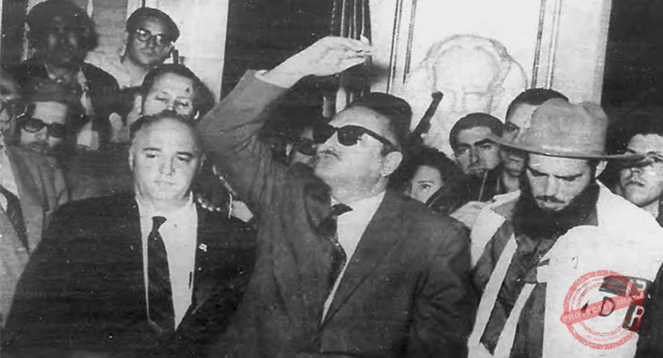 El presidente Manuel Urrutia pronuncia su primer discurso en Palacio desde su despacho oficial. El comandante Rolando Cubela que hixo entrega del Palacio Presidencial escucha atentamente. La Habana, 5 de enero de 1959.
